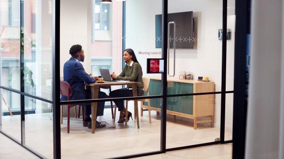 Two people meeting in a conference room talking