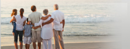 Family with arms around each other while looking out toward the ocean