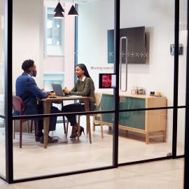 Two people meeting in a conference room talking